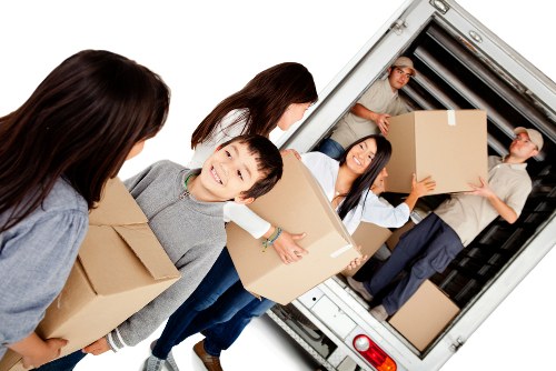 Professional movers loading household furniture into a van
