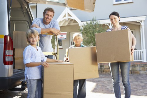 Professional movers transporting furniture through a St Lukes property